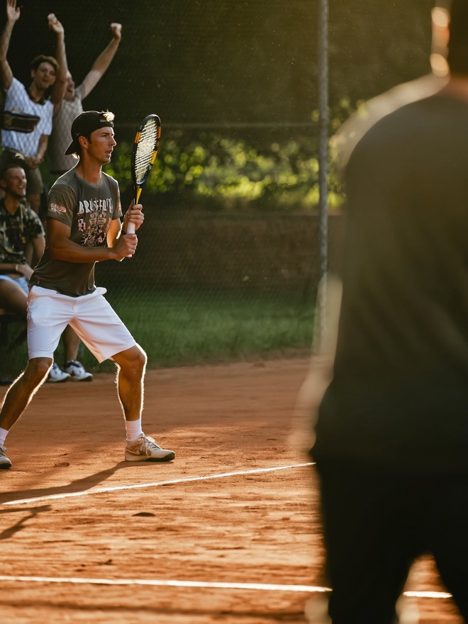 Christophe op de tennisbaan, racket klaar voor de return
